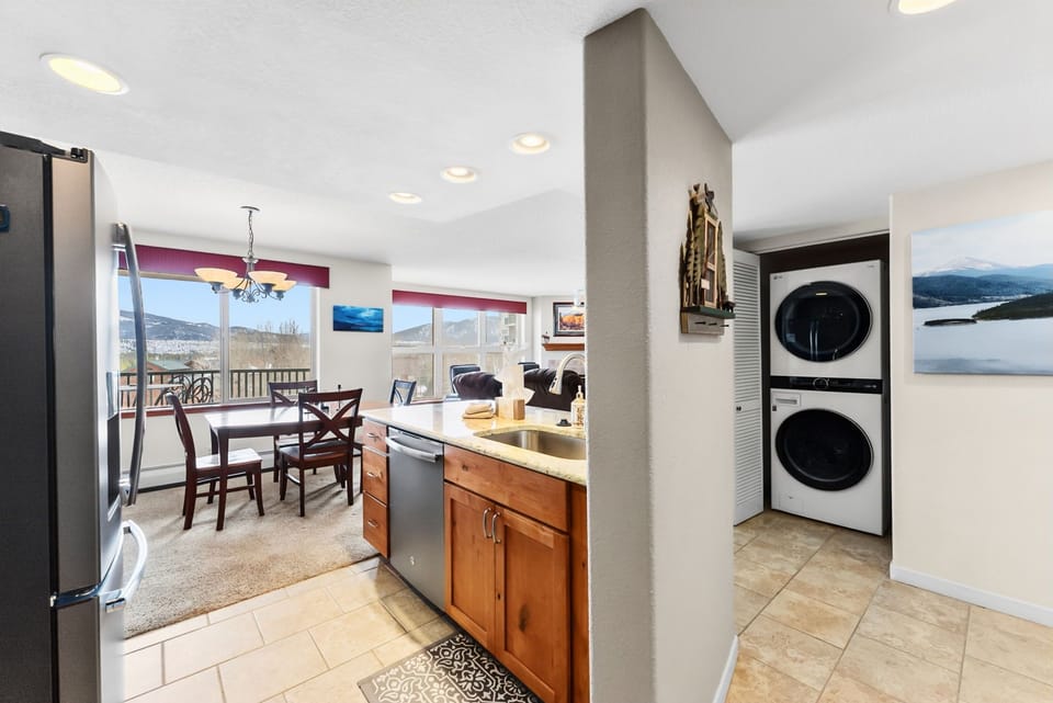 Your open kitchen flows seamlessly into the dining area with mountain views through large windows and convenient in-unit laundry nearby.