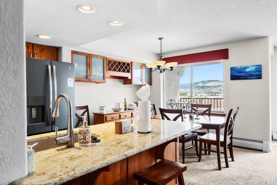 Your fully equipped kitchen flows seamlessly into your dining space, where mountain views frame every meal you'll share.