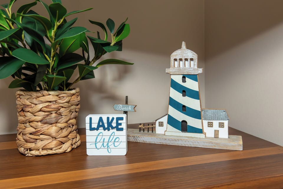 Charming coastal decor awaits you with lighthouse figurines and lake life signs creating a peaceful waterfront ambiance in your retreat.