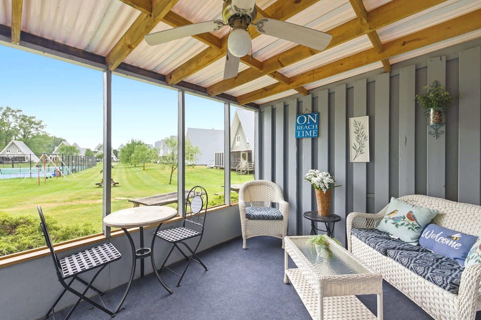 Resort grounds and tennis courts create a scenic porch backdrop.