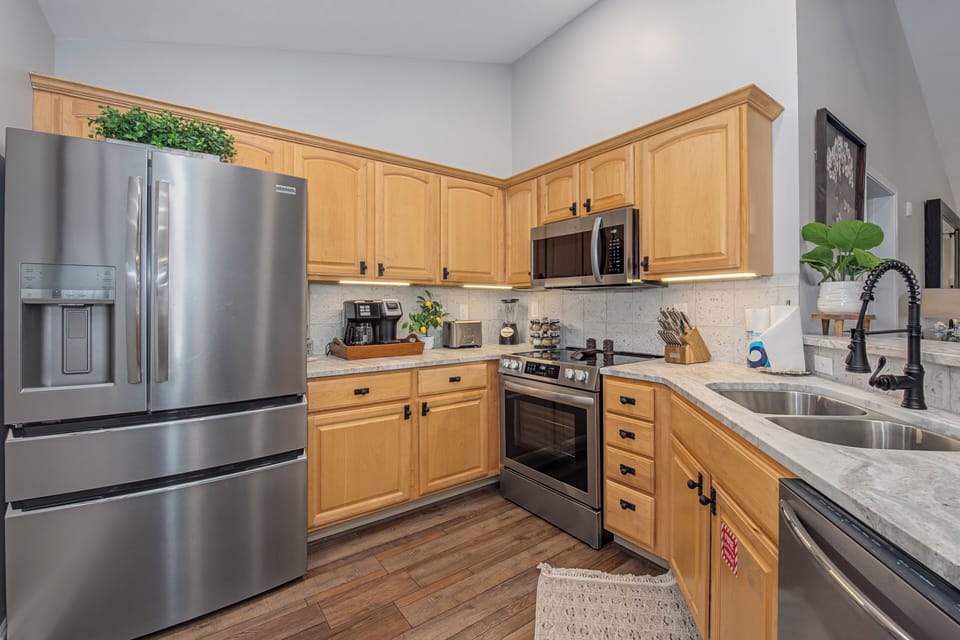 Your fully equipped kitchen awaits with stainless steel appliances, granite counters, and warm wood cabinets - perfect for preparing memorable meals.