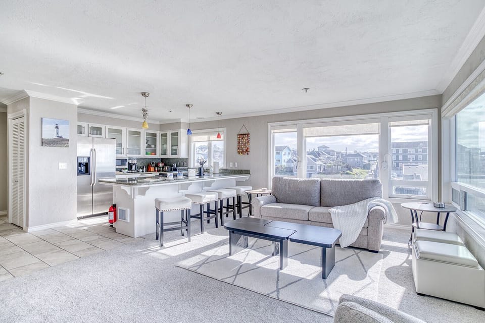 Relax in your bright open-concept space with a fully equipped kitchen, comfortable seating, and stunning city views from floor-to-ceiling windows.