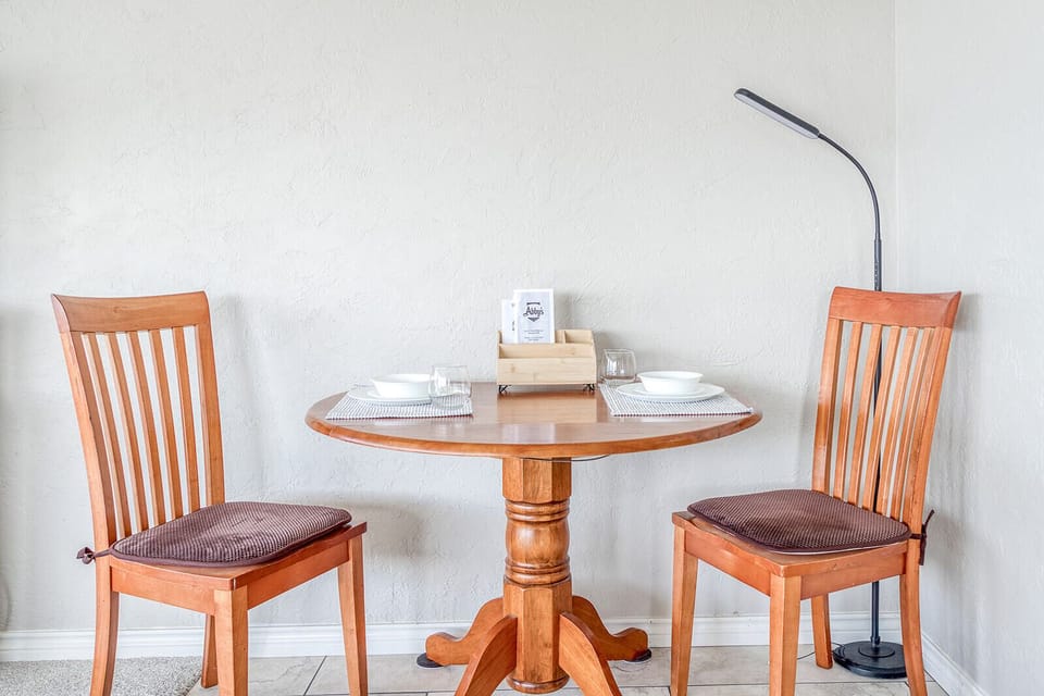 Your intimate dining nook features warm wood furnishings and thoughtful table settings, perfect for cozy meals together.