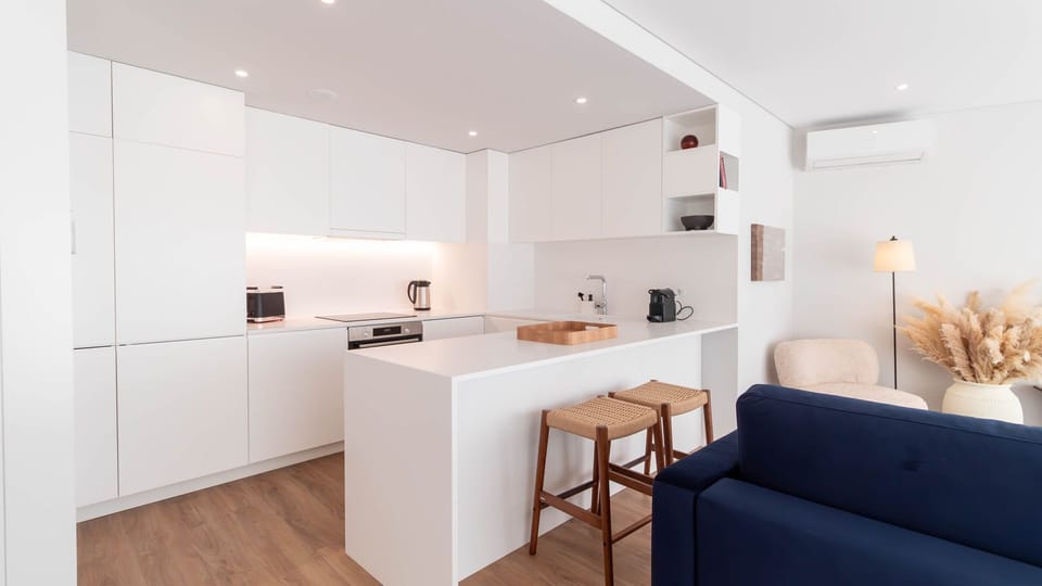Minimalist kitchen with sleek countertops and functional design, complete with a breakfast bar for casual dining. #KitchenGoals #SimpleElegance