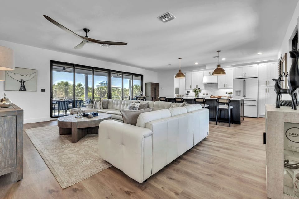 Bright open-concept living space with designer furnishings, plush seating, and seamless indoor-outdoor flow.