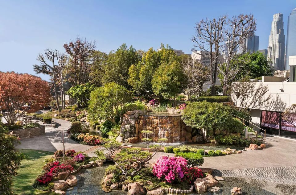 Escape into lush, resort-like gardens framed by city skyline.