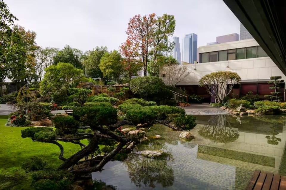 Stroll through tranquil gardens surrounding a reflective koi-style pond.