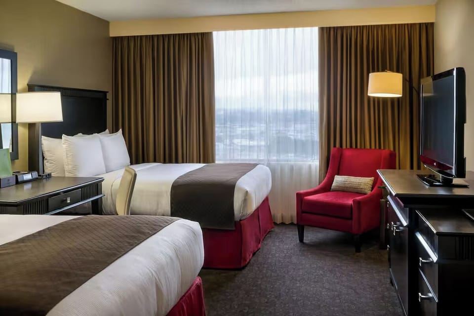 Unwind in crisp linens with skyline views and cozy seating.