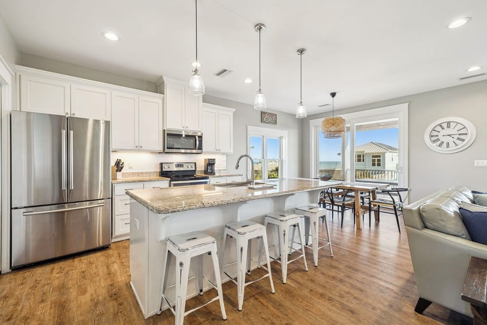 Cook in your gleaming kitchen with granite counters, stainless appliances, and ocean views through bright windows.