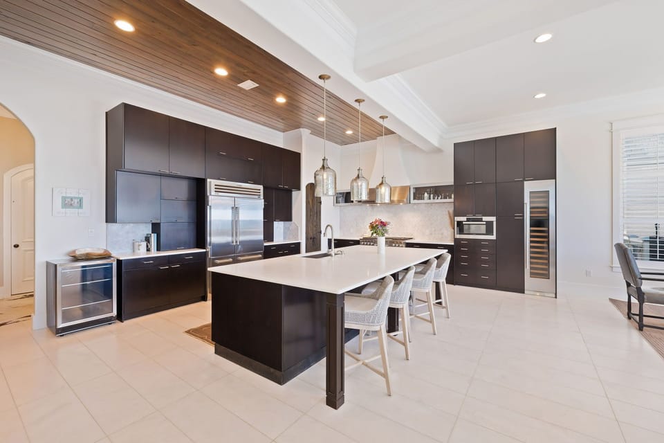 Cook your favorite meals in this stunning modern kitchen featuring sleek dark cabinets, premium appliances, and a spacious island perfect for gathering.
