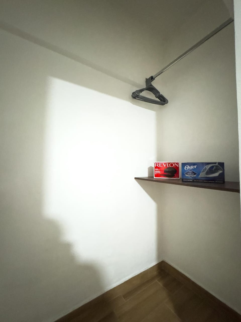 Cozy, minimalist closet with natural light and wooden flooring