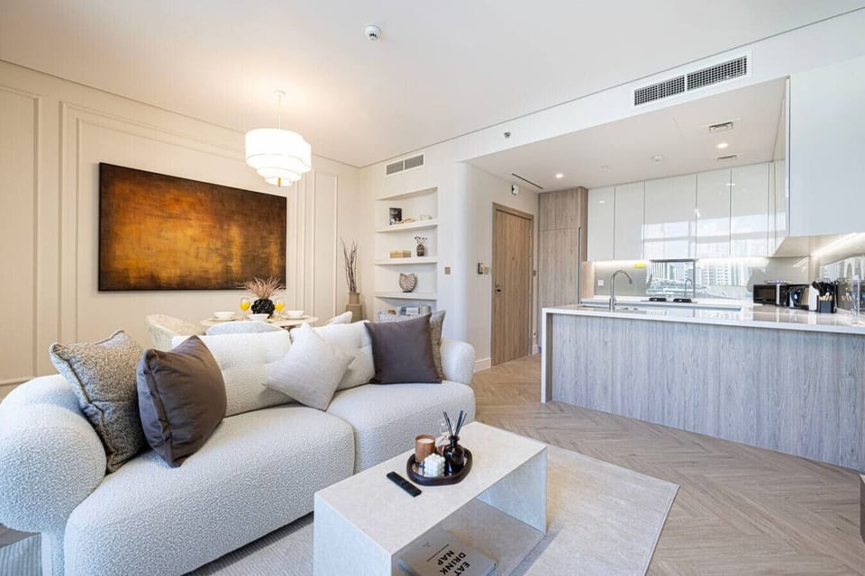 Stylish open-concept living with a luxe sofa, chic dining space, and a fully equipped modern kitchen—designed for comfort and effortless stays.