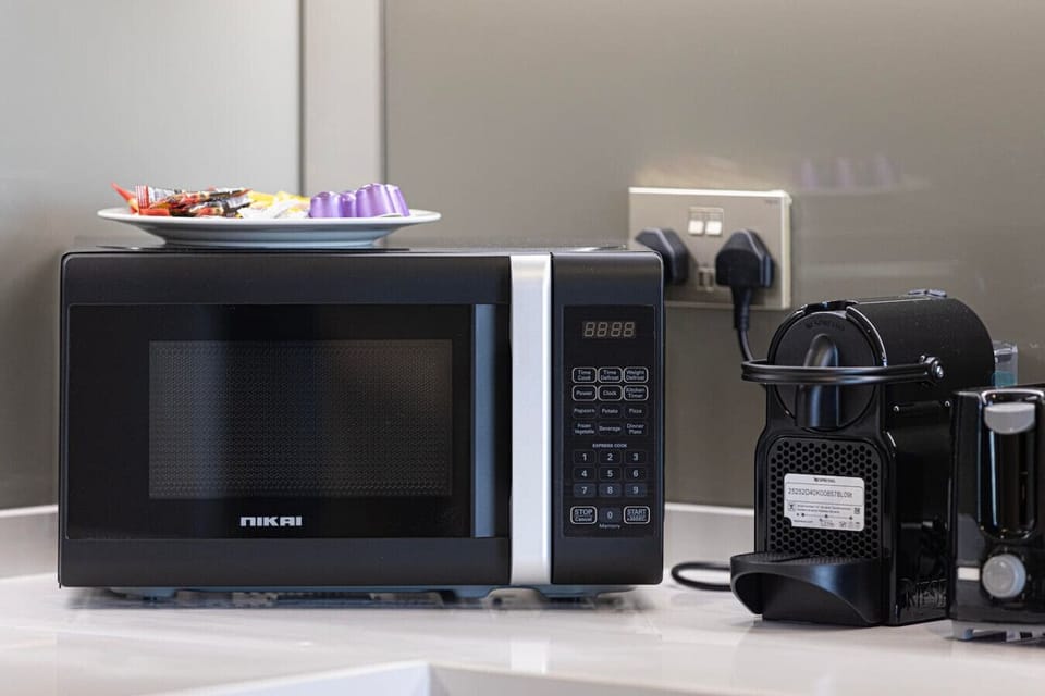 Fuel your day with ease — Enjoy a convenient kitchen setup featuring a modern microwave and Nespresso coffee machine, complete with complimentary snacks and pods for a perfect start to your stay.