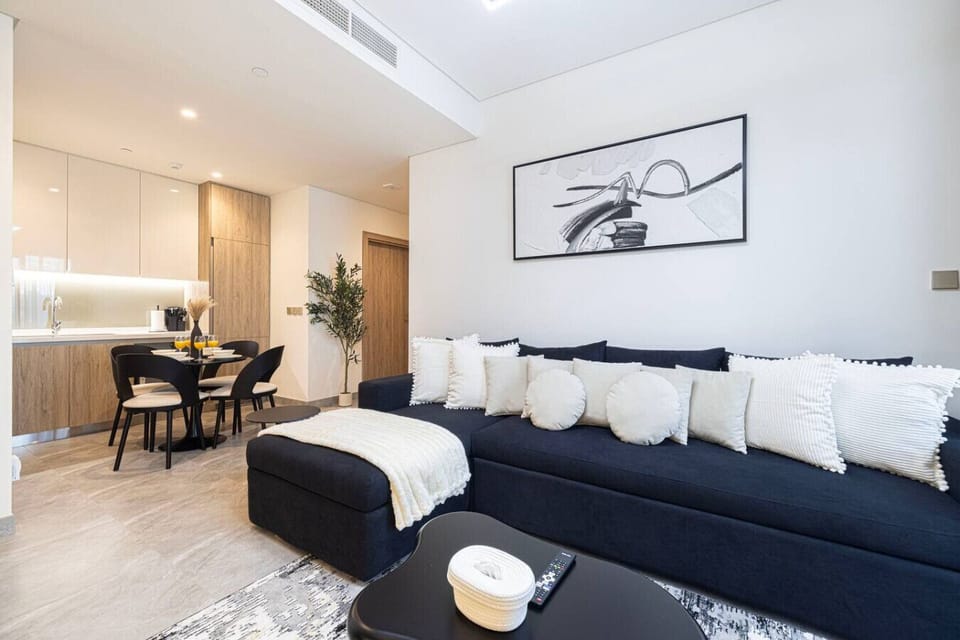 Bright, elegant lounge with a spacious sofa and seamless flow into the dining and kitchen area.