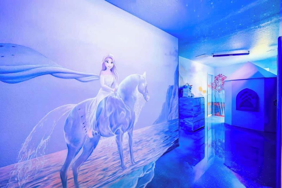 Frozen Themed Bedroom featuring a custom Frozen castle bed with 2 queen-over-queen bunk beds, tube slide, hideaway play area, special effects lighting, ensuite bathroom with dual vanity and shower. 