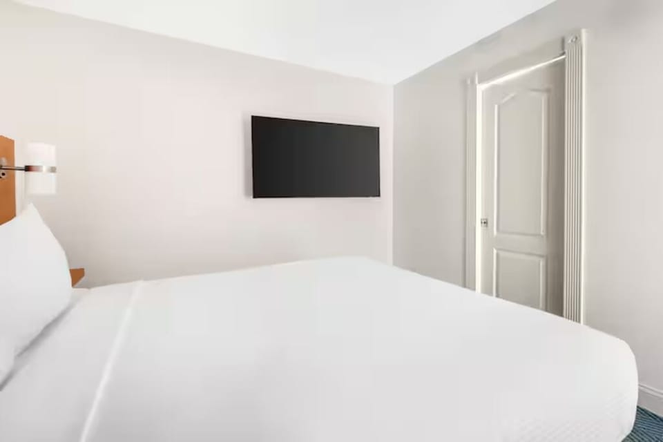 Unwind with wall-mounted TV and calm, minimalist comfort.