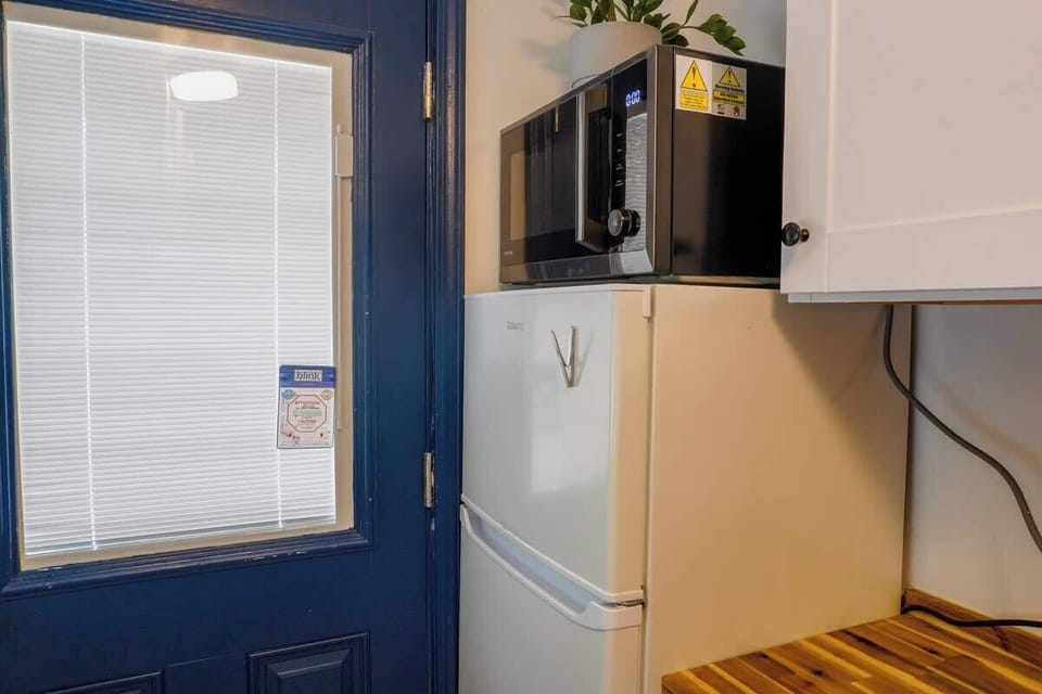 Compact kitchenette with essential appliances and everything needed for quick meals or snacks.
