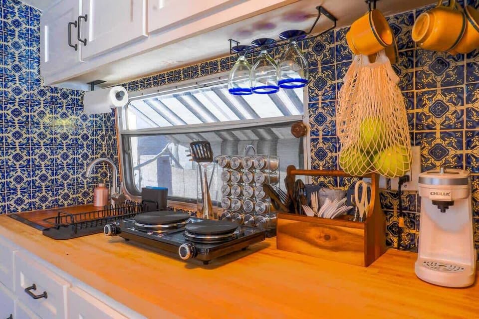 Camper kitchenette with stove, sink, and fridge