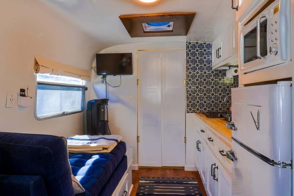 Camper kitchenette with stove, sink, and fridge