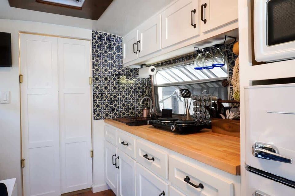 Camper kitchenette with stove, sink, and fridge