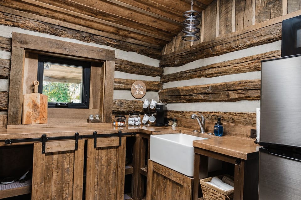 Cozy log cabin kitchenette with farmhouse sink and charming coffee bar
