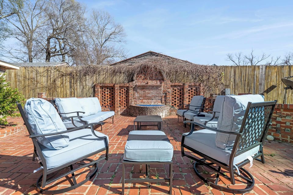 This secluded outdoor lounge area offers a masterclass in rustic charm, blending the warmth of aged red brick with comfortable, modern outdoor furniture.