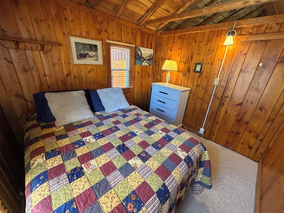 Queen bedroom with dresser and clothes hangers