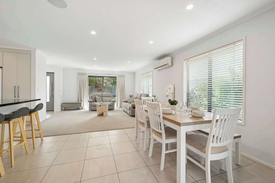 Spacious open-plan living and dining with heat pump air conditioning and garden views — modern family home in Rotorua NZ