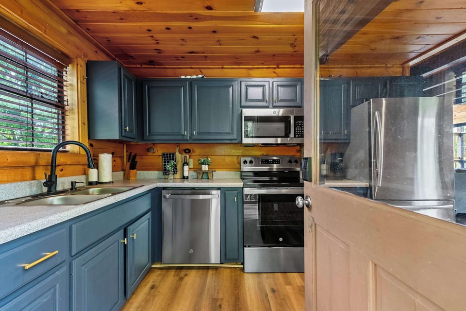The full kitchen pulls no punches — everything you need to cook from scratch, with a window that turns even dish duty into a mountain moment.