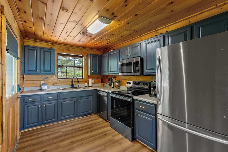 Slate-blue cabinets, full stainless suite, and enough counter space to cook a real meal — the kitchen at Sunlit Elephant is built for groups who eat well.