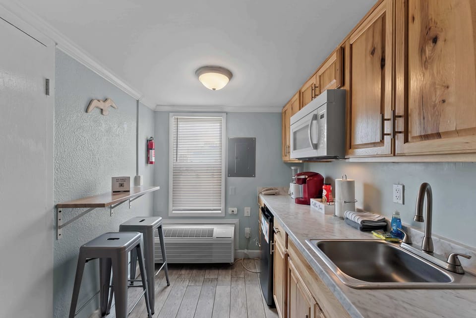 Kitchenette with mini fridge, microwave, sink, coffee maker, and bar seating