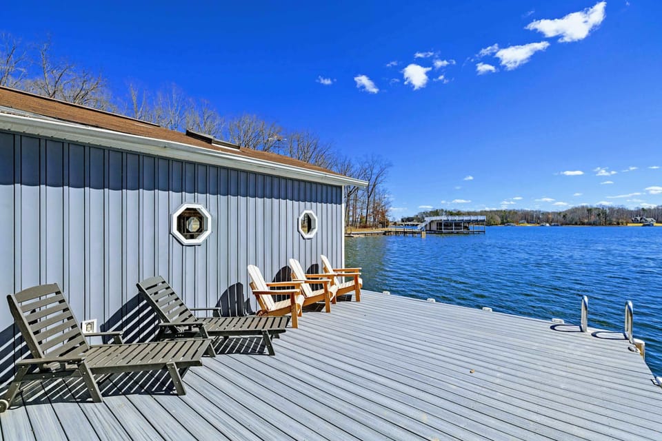 Dock Lounge - Adirondack chairs and loungers line the dock beside the boathouse, with porthole windows adding a nautical touch.