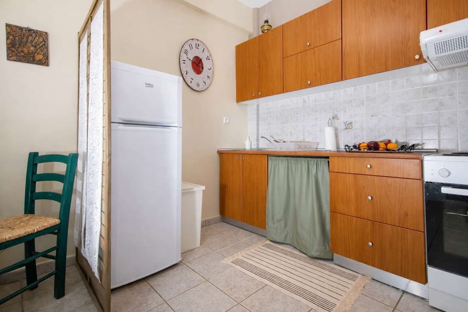 Fully equipped kitchen featuring a refrigerator, stove, coffee machine, toaster, kettle and ample cabinet space. The layout is practical and efficient, offering all essentials for cooking and dining in a comfortable and well-organized space