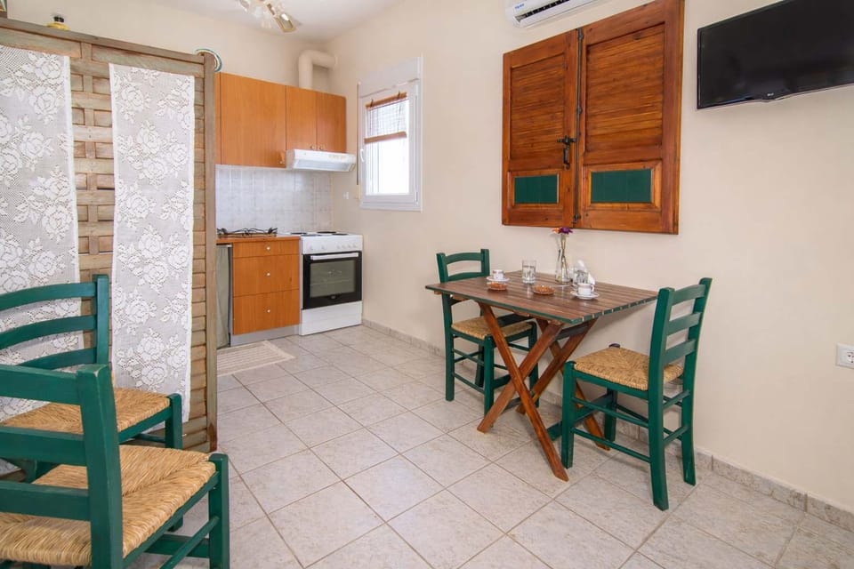 Cozy kitchen and dining area with wooden cabinets, a small table, and traditional decor. The compact setup is fully functional, making it easy to prepare meals while enjoying a cozy and homely environment