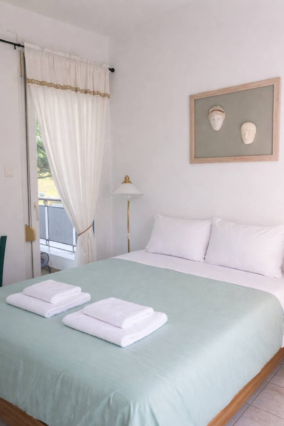 Comfortable and well-lit studio featuring a double bed beds with wooden details and direct access to a private bathroom, offering both convenience and a relaxing atmosphere for your stay