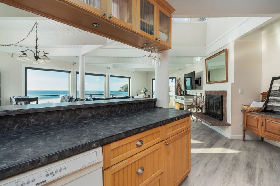 Cook with stunning ocean views through your panoramic windows, where the kitchen seamlessly flows into your bright living space with elegant stone countertops.