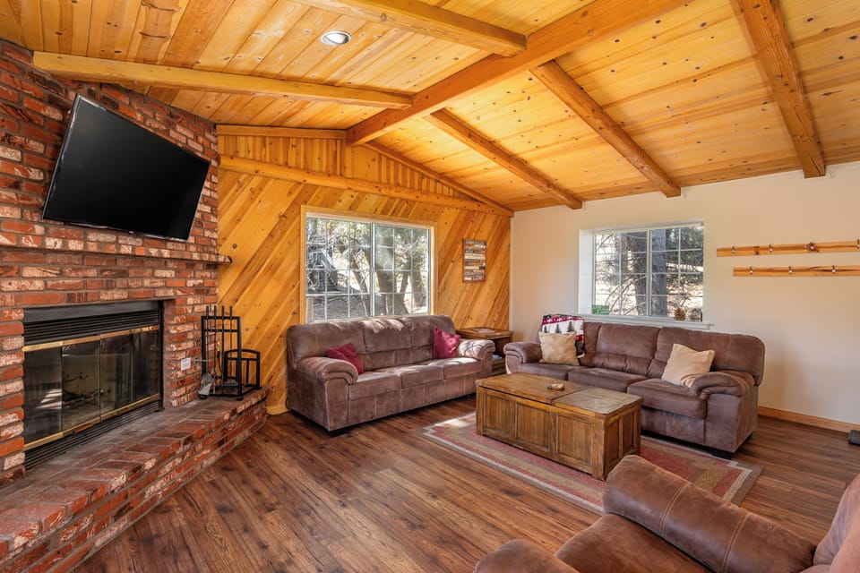 Cozy up in your spacious living room with exposed wood beams, brick fireplace, and leather seating perfect for mountain evenings.