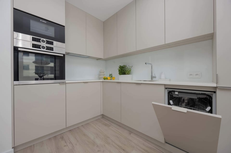 A sleek, modern kitchen with built-in appliances and a minimalist design. Perfect for preparing meals in comfort and style.