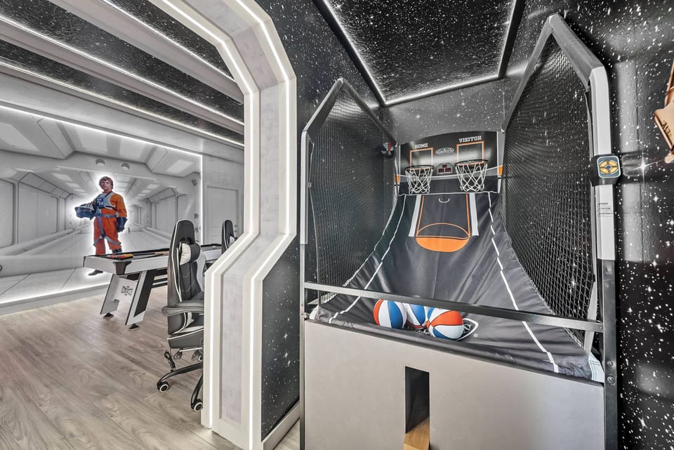 Step into a playful atmosphere featuring a unique basketball arcade game set against a sleek, space-themed backdrop. The modern design is complemented by ambient lighting and polished surfaces, perfect for both relaxation and fun.