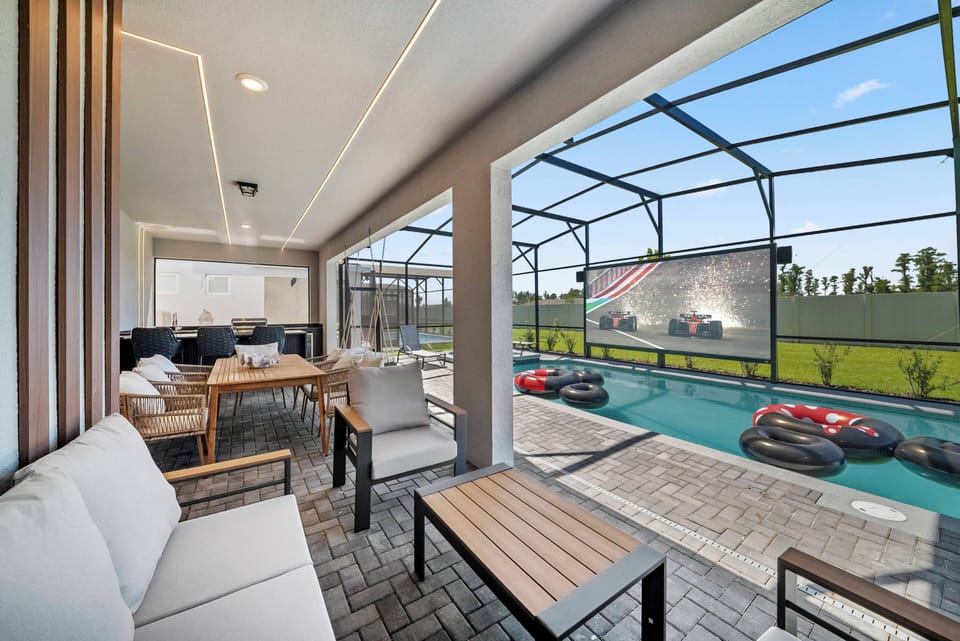 Experience our stunning outdoor lounge, blending modern seating with natural wood accents. This spacious screened area provides a perfect view of the sparkling pool, inviting you to relax or entertain in style.