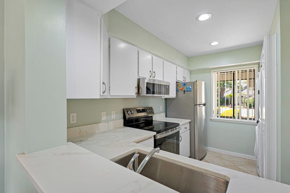 This kitchen is clean, efficient, and designed for easy vacation living. Updated countertops and stainless steel appliances give it a fresh, modern feel, while the layout keeps everything within reach.