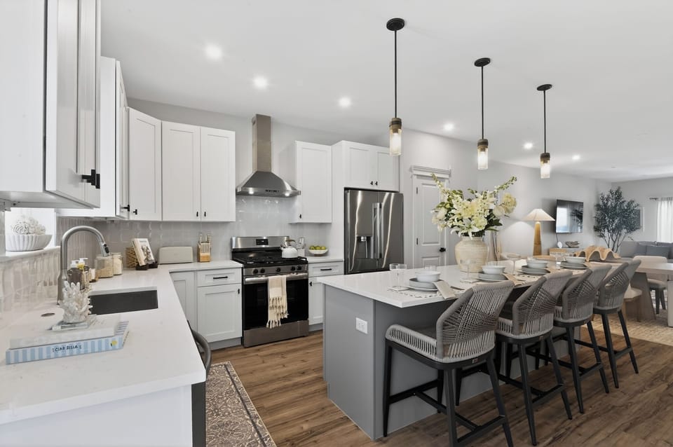 Bright kitchen with gas stove dishwasher, microwave and other appliances.