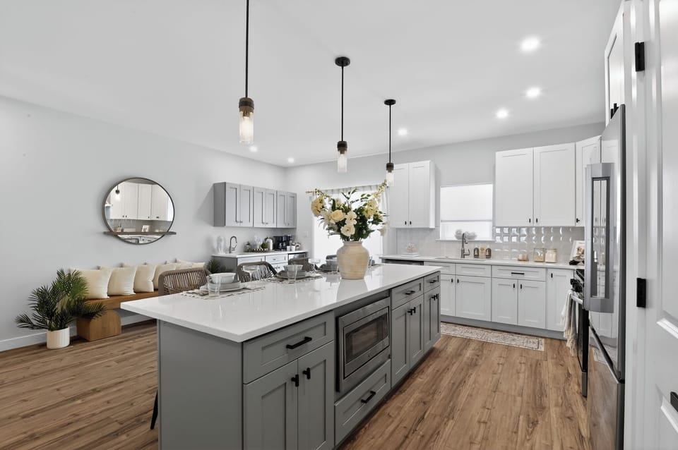 Large kitchen w/ access to rear deck. Bar stools & bench for additional seating.