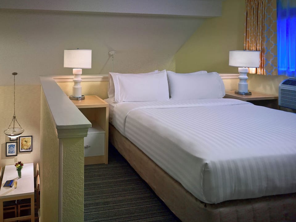 Recharge upstairs in a quiet loft bedroom with soft glow.