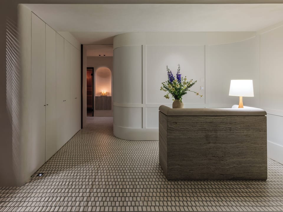 Arrive to a serene, gallery-like lobby with soft lighting.