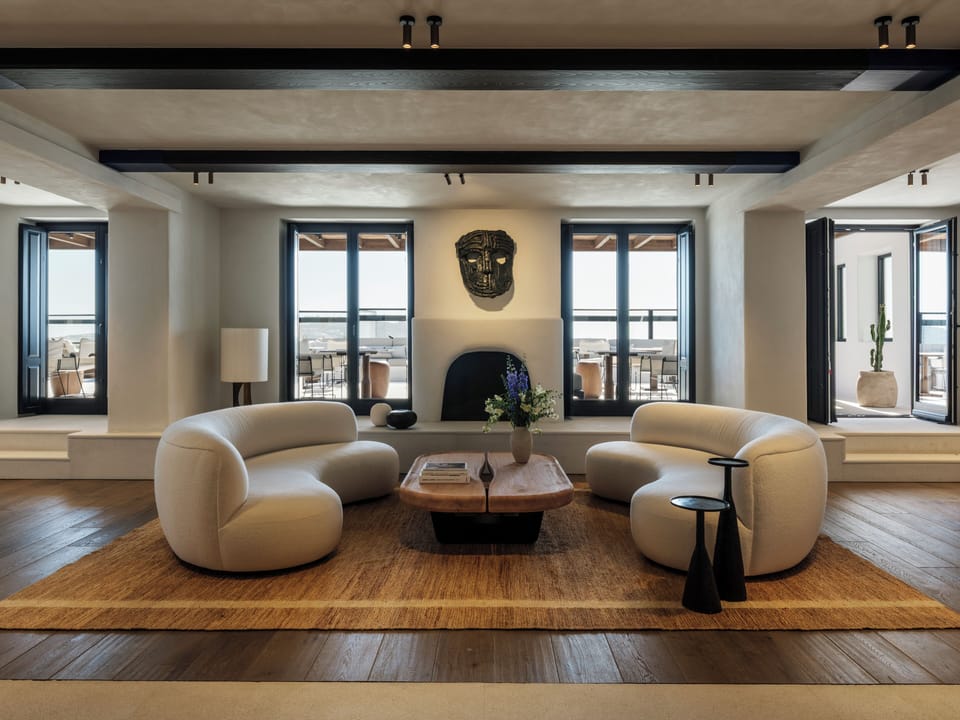 Unwind on sculptural sofas as sunlight spills through open doors.