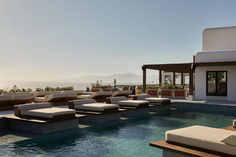 Dive into sunlit serenity with panoramic sea-view loungers.