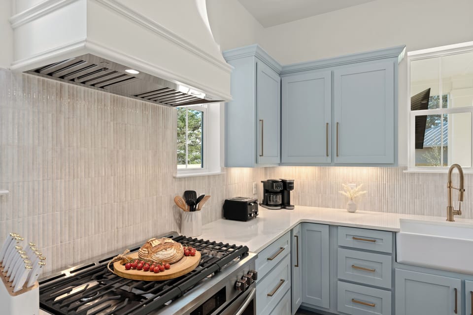Beautifully appointed kitchen with quartz counters, designer lighting, and plenty of space to prep and gather.