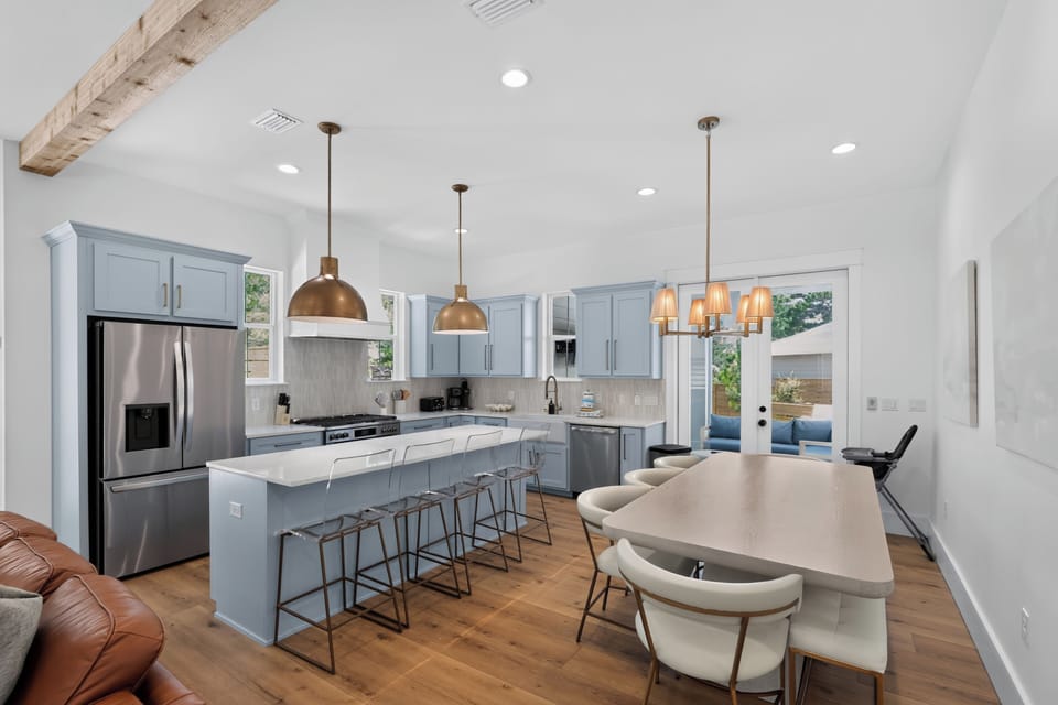 Stylish chef’s kitchen with soft coastal tones, generous seating, and an inviting space for gathering over meals.