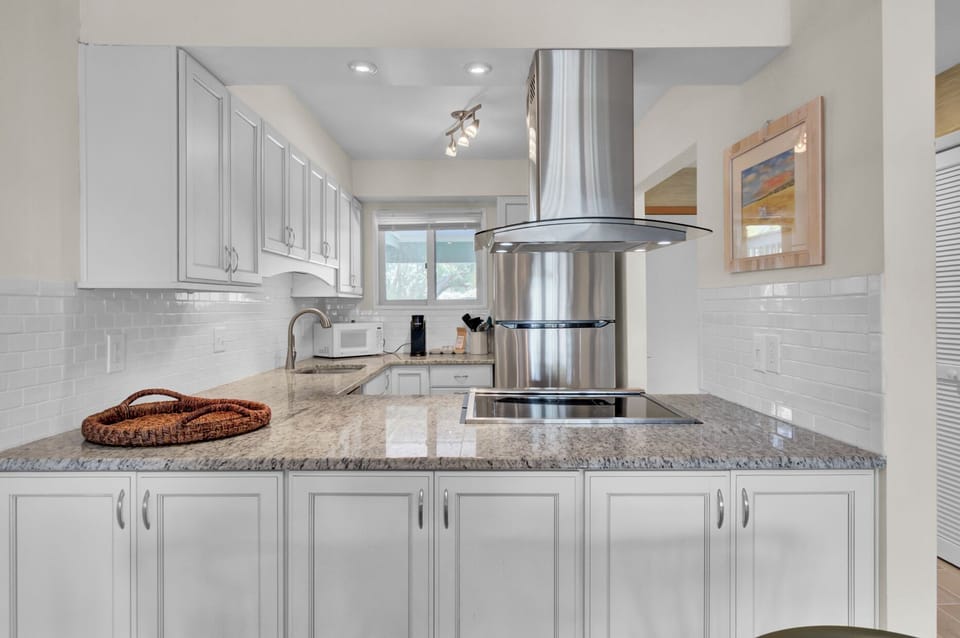 Bright white kitchen with granite counters, subway tile, and everything set up for easy Charleston cooking.